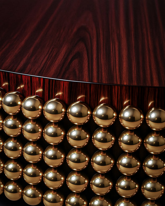 Close-up of polished gold-plated stainless-steel spheres under Lustra Coffee Table.