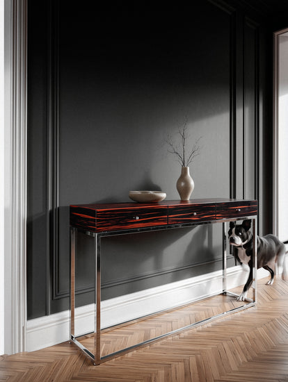 Console table with decorative items against a dark wall, dog standing on the right.