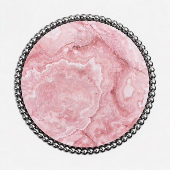 Contemporary luxury dining table with translucent pink onyx surface and reflective metal base.