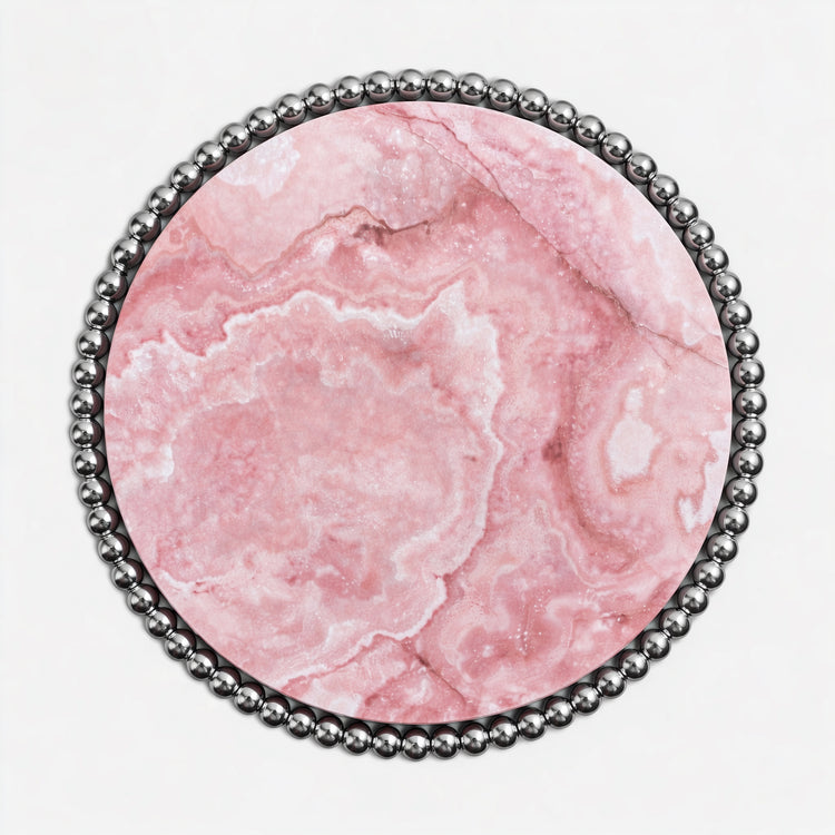 Contemporary luxury dining table with translucent pink onyx surface and reflective metal base.