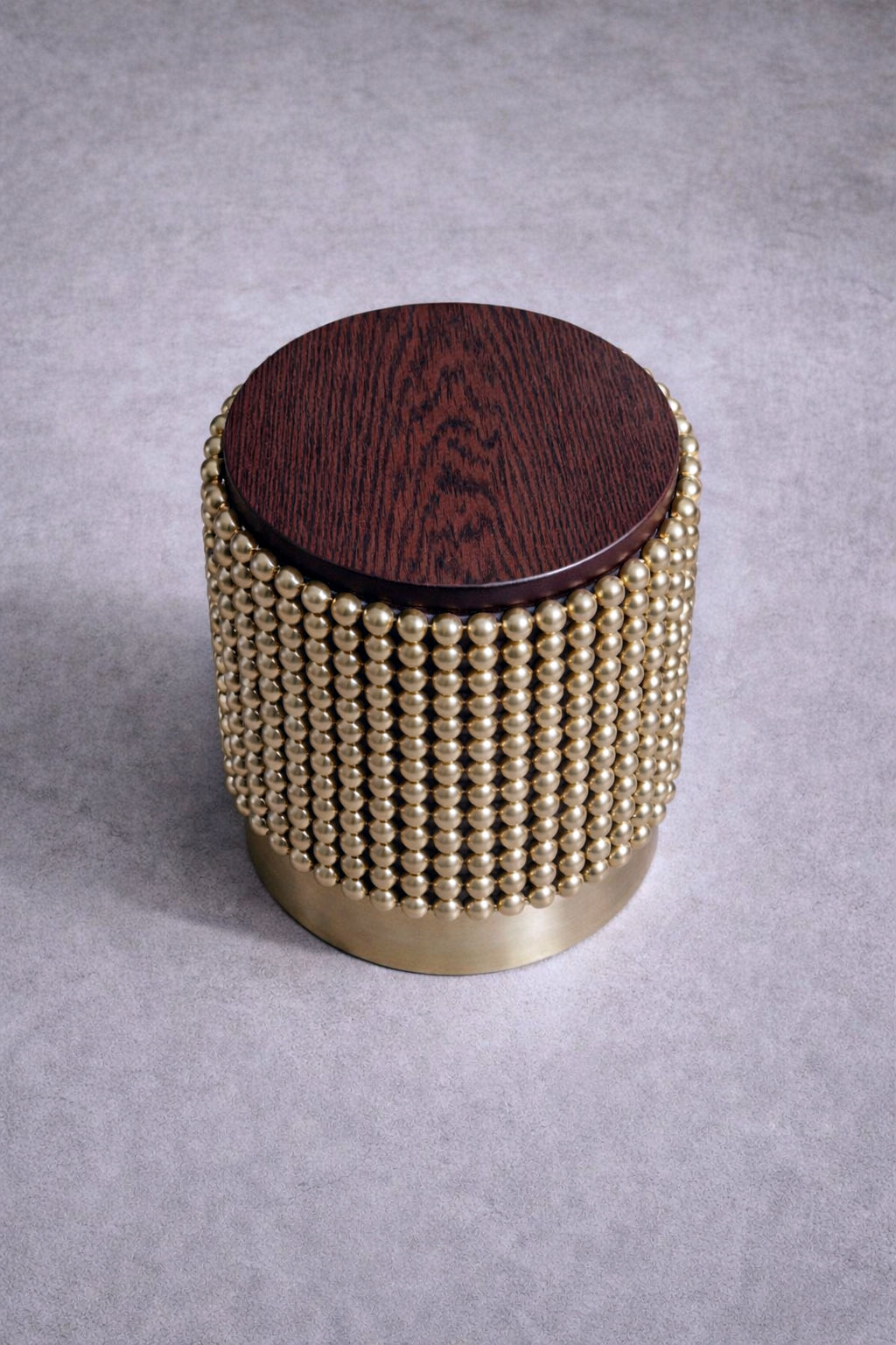 Luxury side table with polished gold spheres and deep brown wenge finish