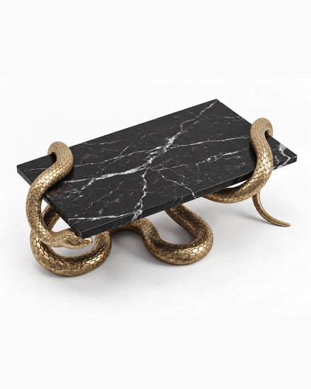 Luxury sculptural coffee table with black marble surface and handcrafted serpent-inspired metal base.