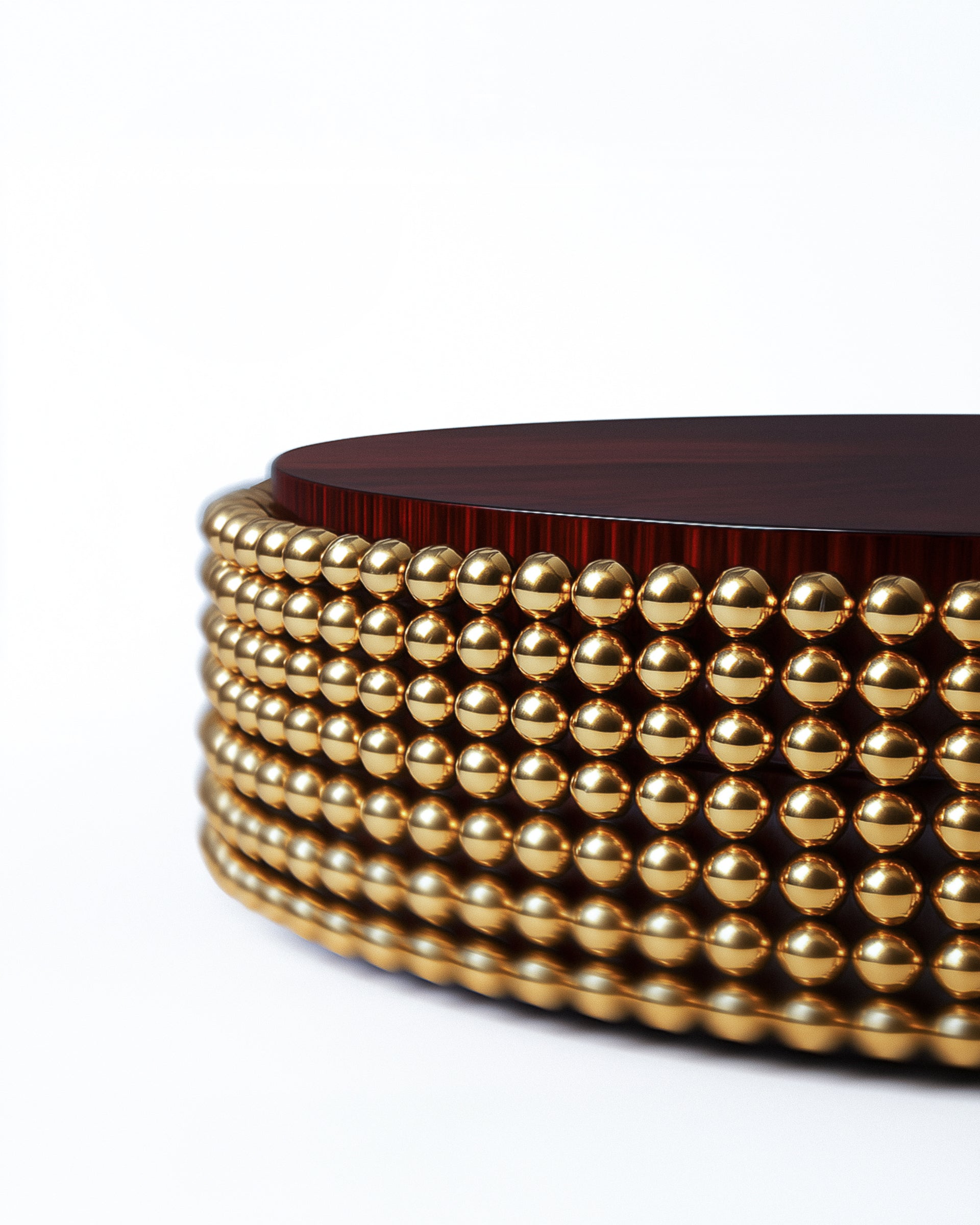 Luxury coffee table with reflective brass-gold base and dark wooden top in studio lighting.