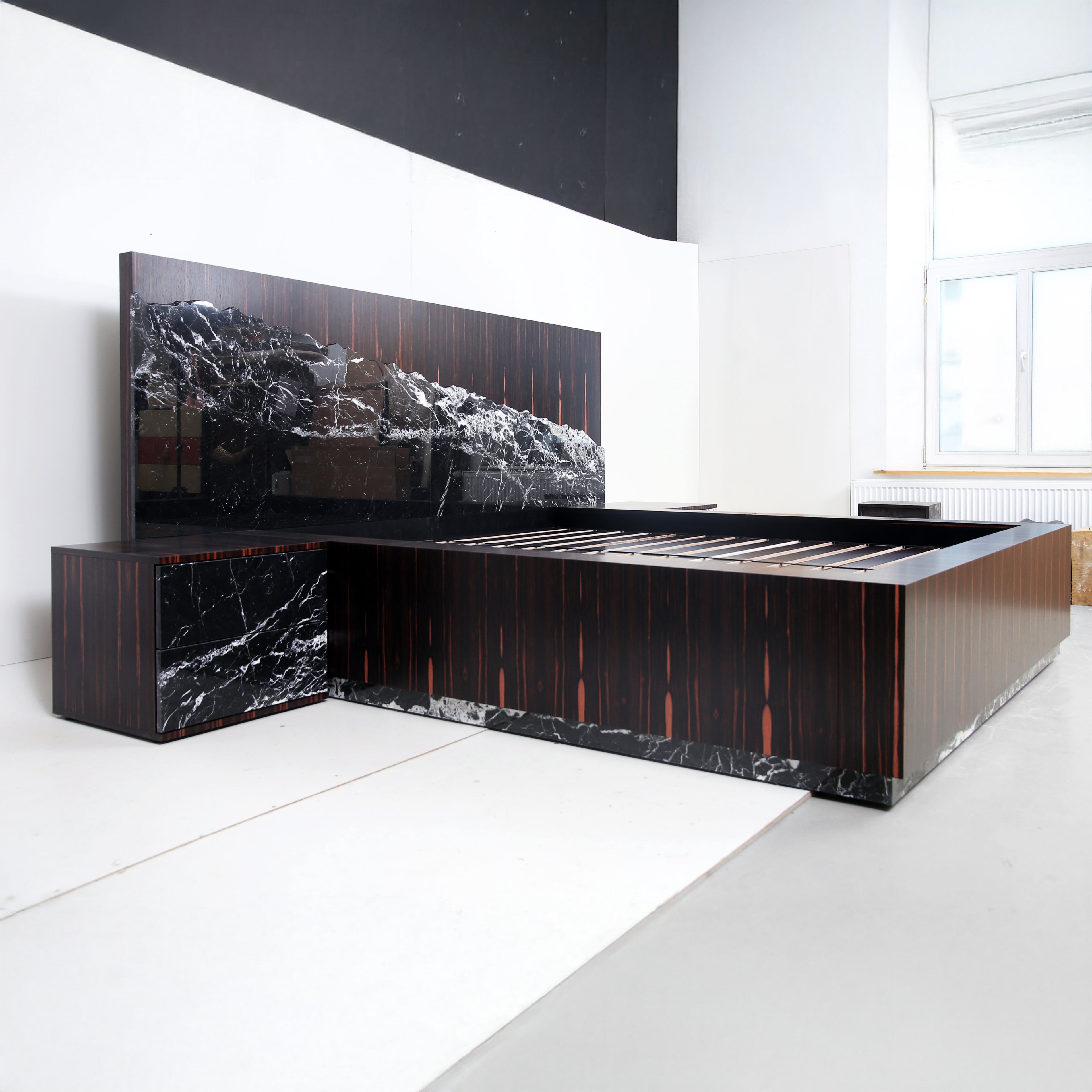 Luxury bed with dramatic black marble headboard and Macassar ebony frame, designed by Hekla Property.