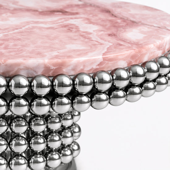 Round pink onyx dining table featuring sculptural chrome stainless steel sphere pedestal.