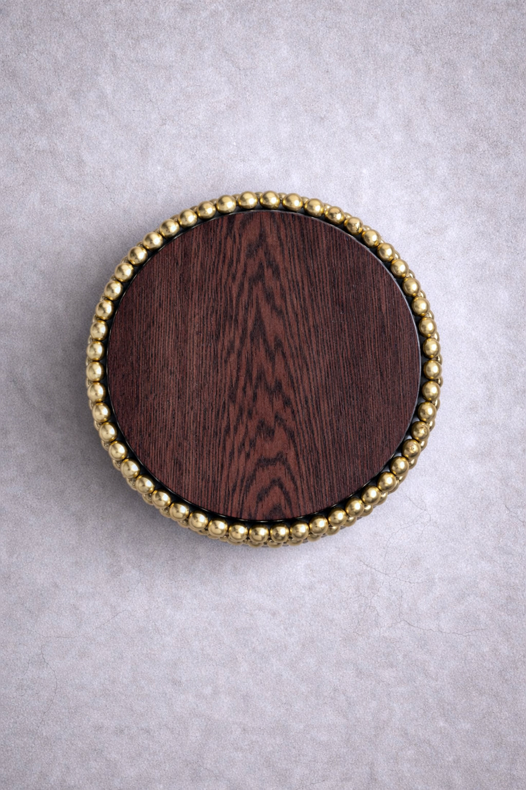 Round side table with gold-plated sphere base and dark wood top