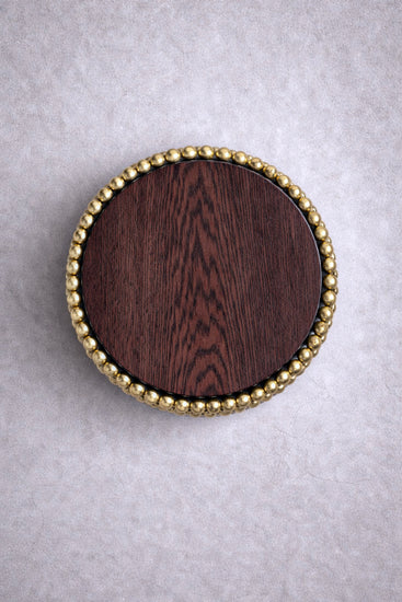 Round side table with gold-plated sphere base and dark wood top