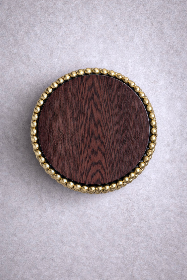 Round side table with gold-plated sphere base and dark wood top