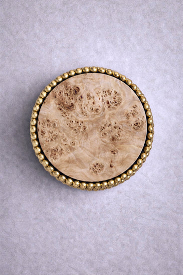Round side table with reflective gold sphere base and poplar burl top, designed by Railis Kotlevs