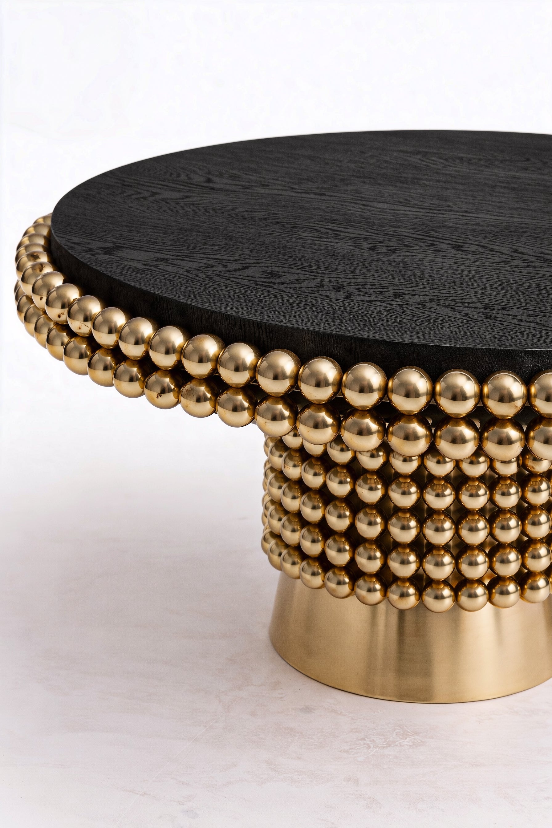 Modern sculptural dining table with black ash wood veneer and polished gold sphere base