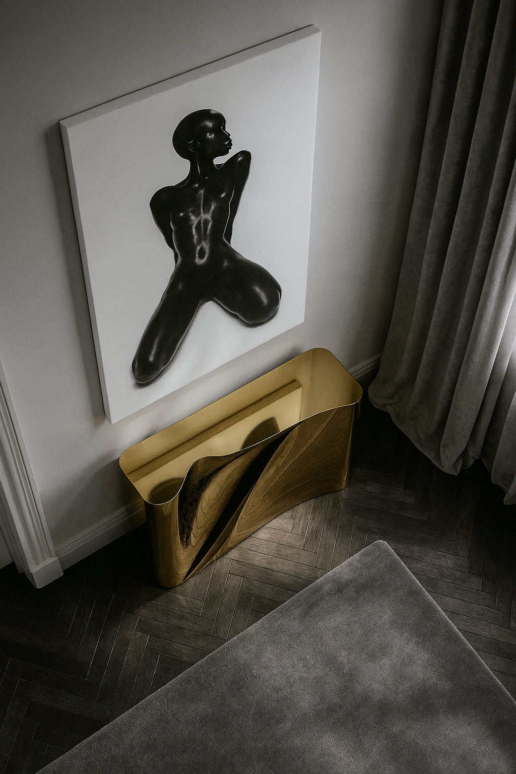 Gold sculpture on a gray rug with a black and white abstract painting of a figure on a white wall.