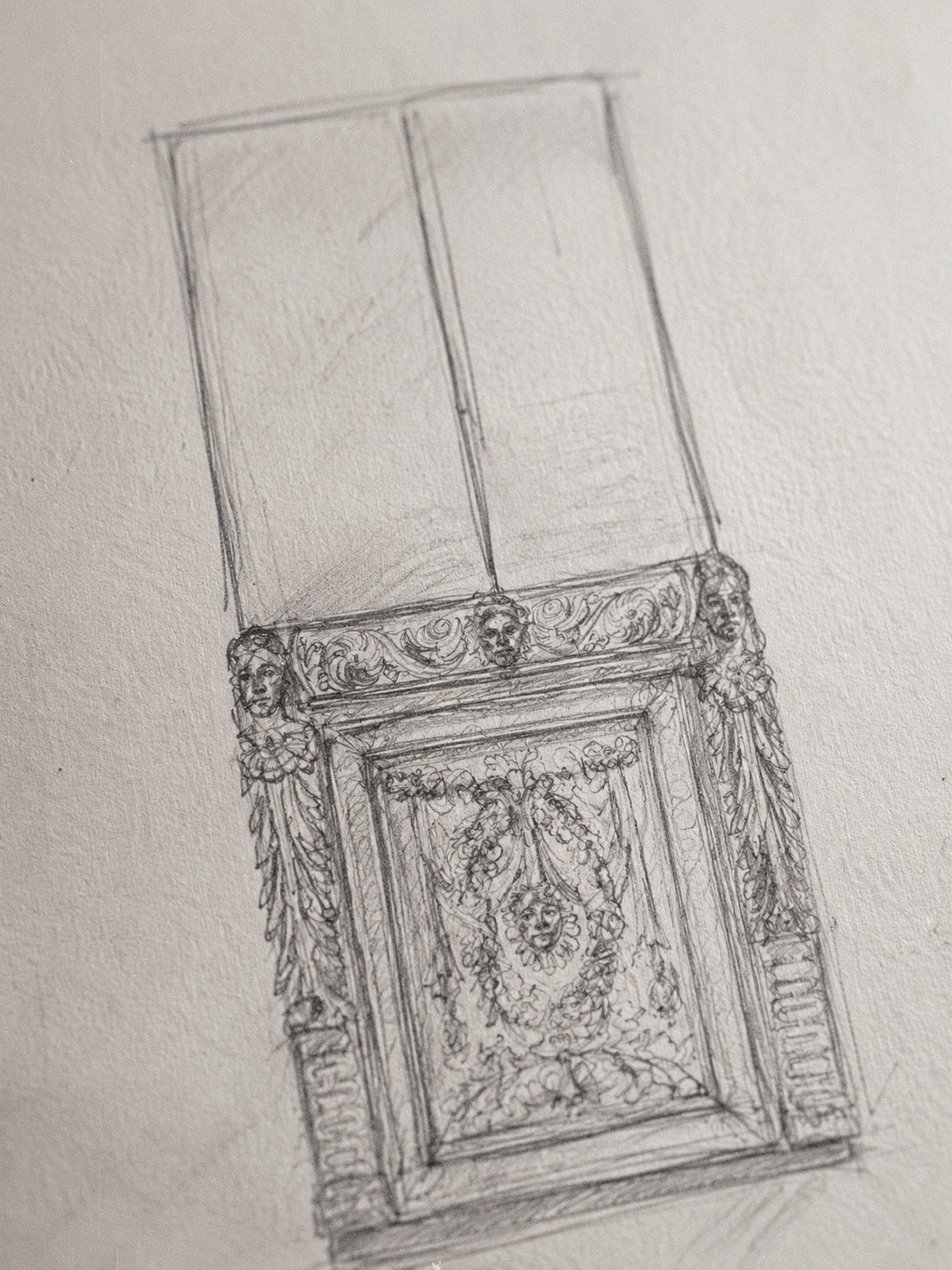 A pencil sketch of an ornate classical wall panel or decorative molding, drawn on textured off-white paper.