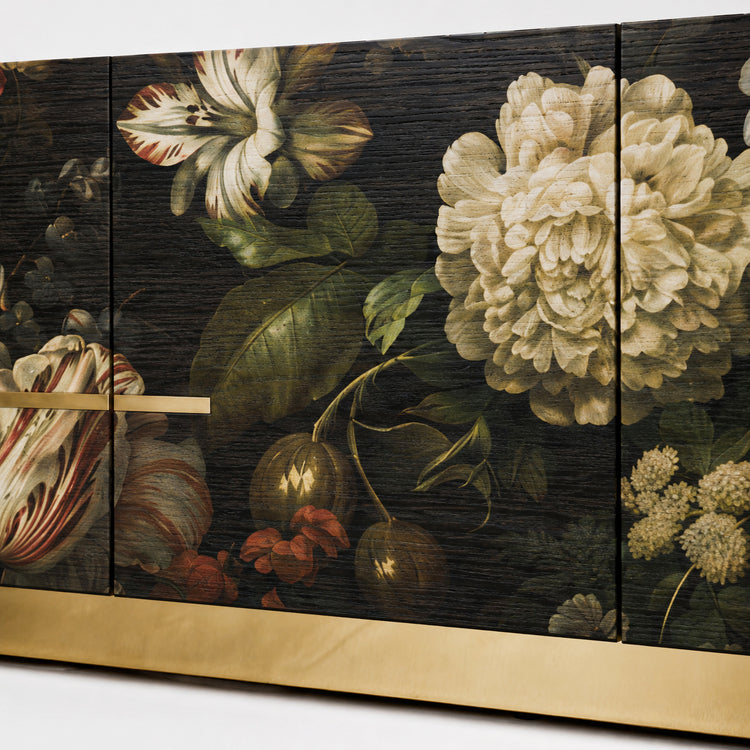 Close-up of the Aurelia sideboard showing layered floral artwork, visible dark oak grain and refined brass detailing.