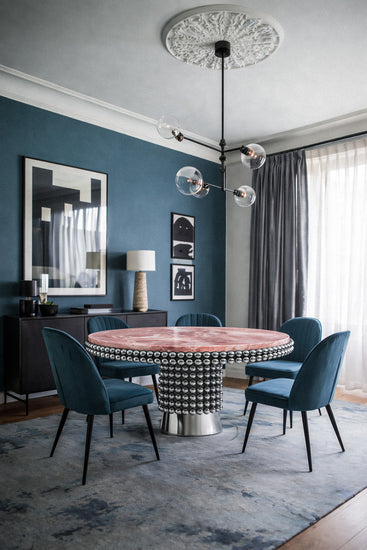 Statement dining table in natural pink onyx with clustered chrome sphere foundation.