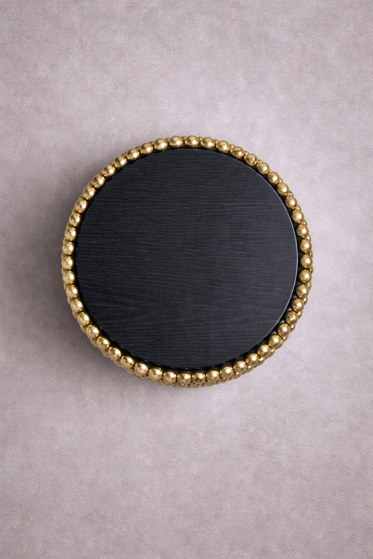 Round side table with reflective gold sphere base and black ash top, designed by Railis Kotlevs