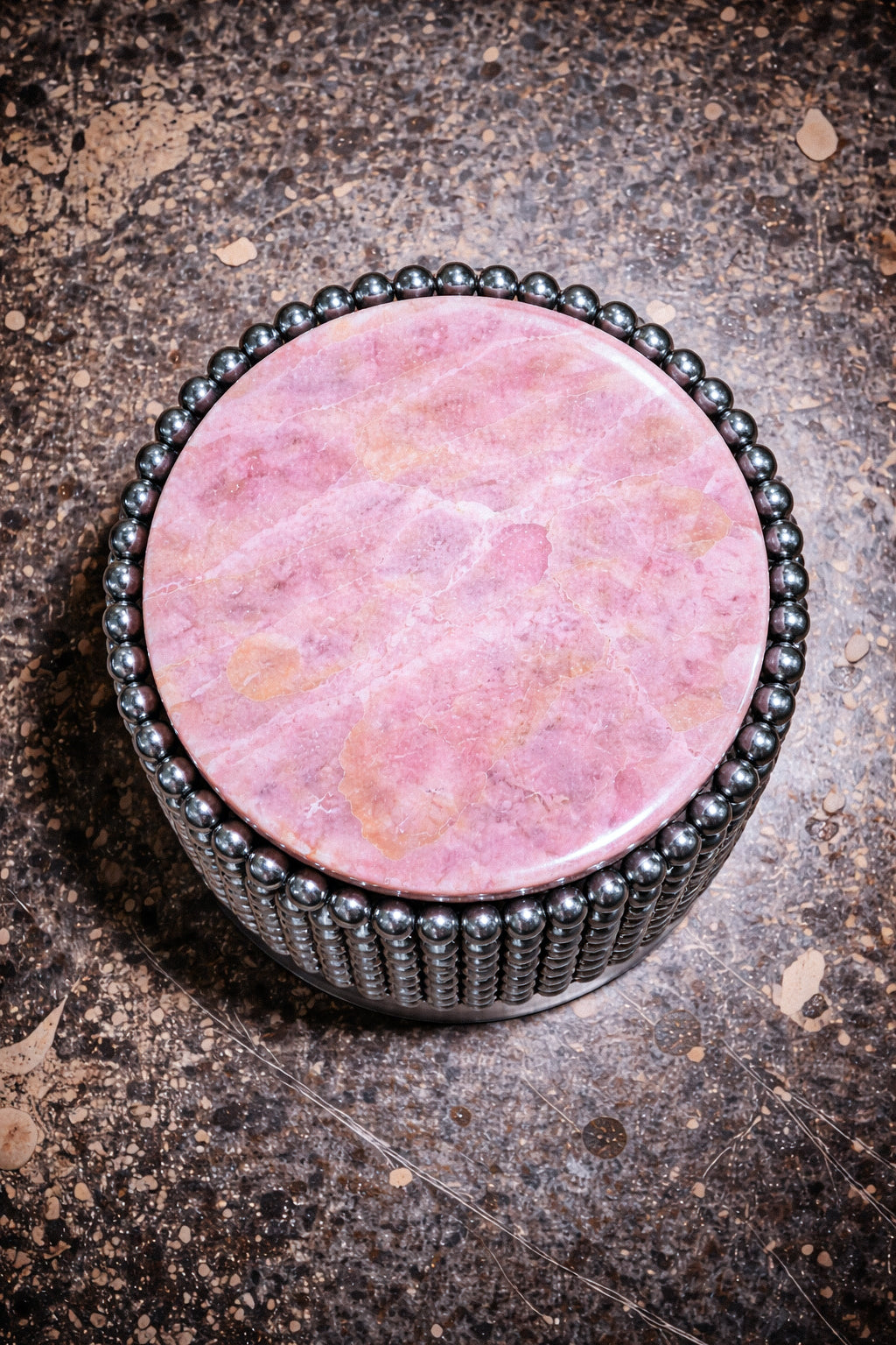 Sculptural side table with polished chrome ball base and round pink onyx tabletop