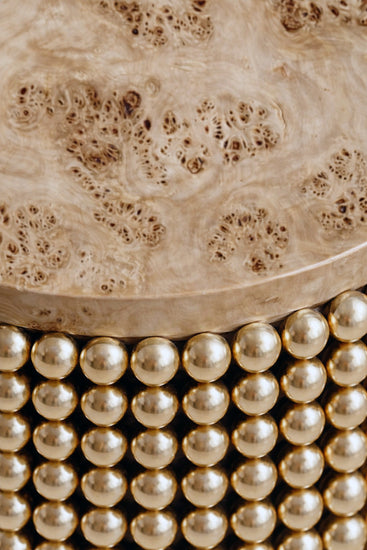 Sculptural side table featuring gold metal spheres and poplar burl tabletop, designed by Railis Kotlevs