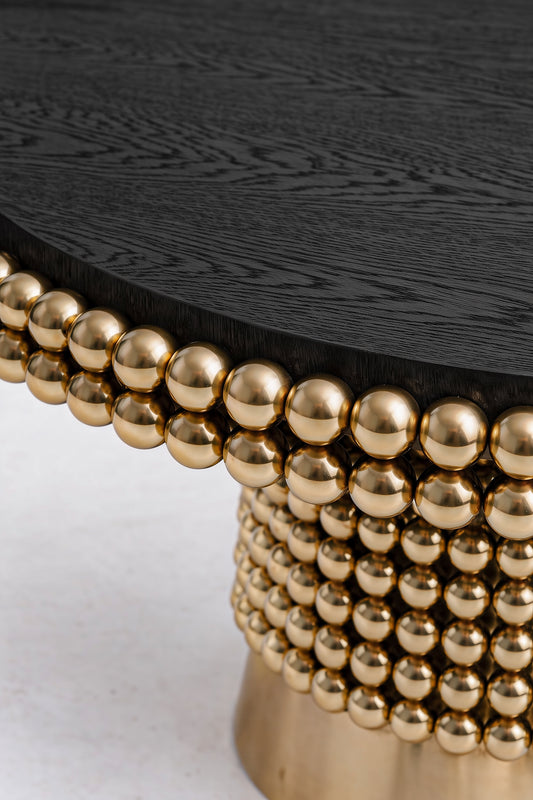 Luxury dining table featuring black ash veneer tabletop and sculptural gold sphere pedestal base
