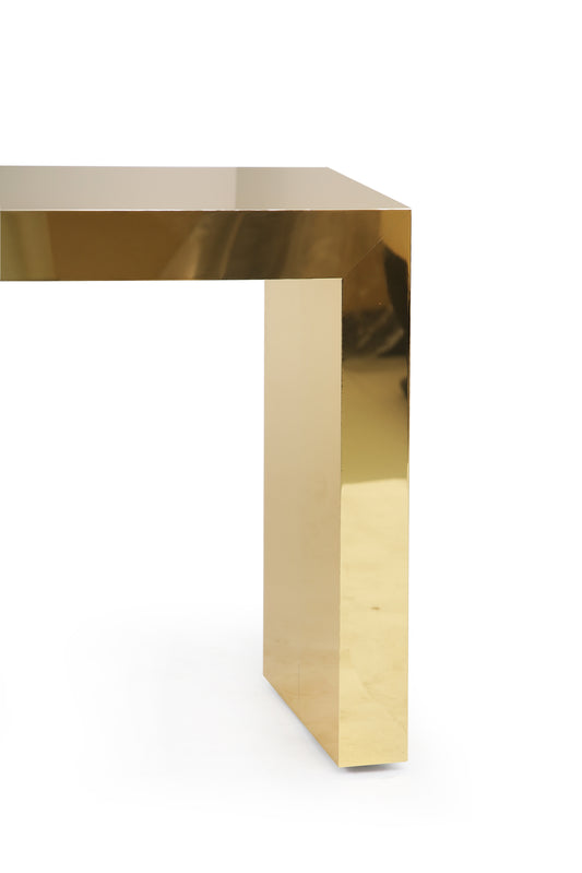 High-end polished brass hallway console styled with décor in an elegant space.