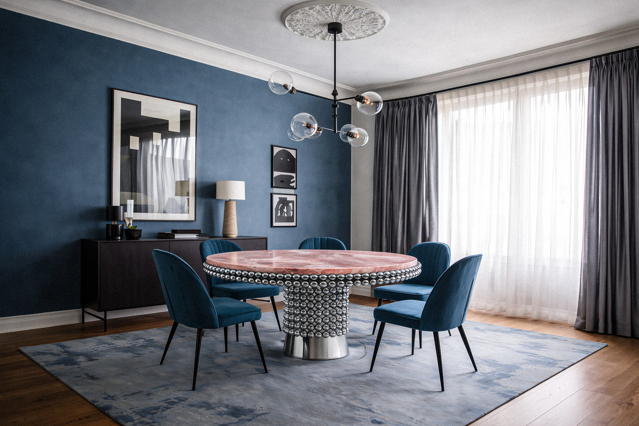 Designer dining table with blush-toned onyx top and high-polish chrome base detail.