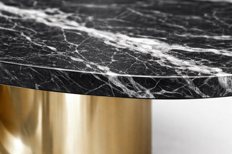 High-end oval marble dining table with reflective gold base in modern classic dining room.