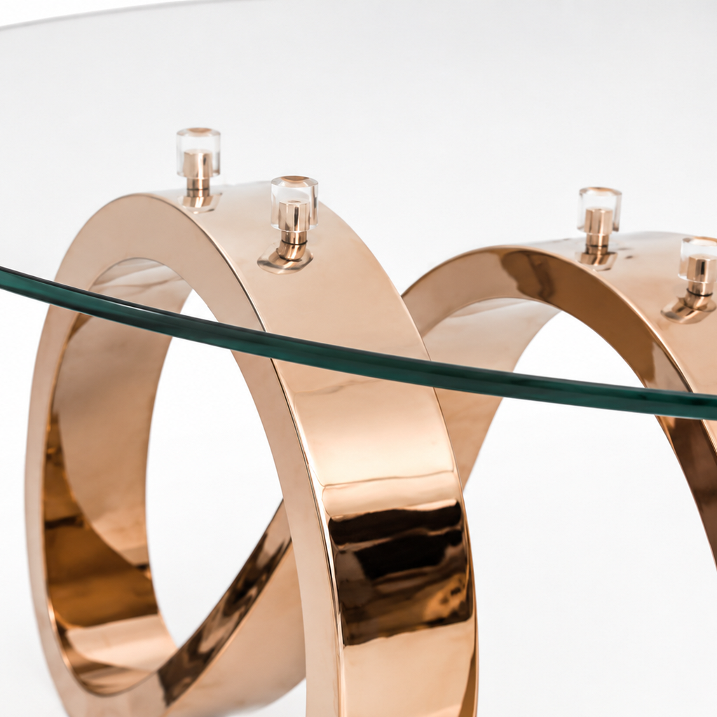 Luxury glass coffee table with artistic curvy metal base in polished copper finish.