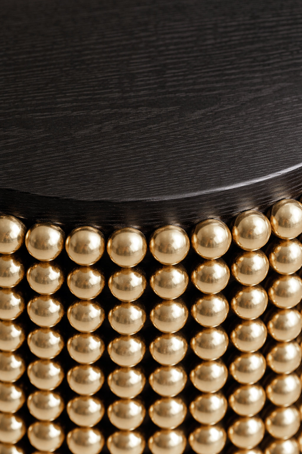 Sculptural side table featuring gold metal spheres and black ash tabletop, designed by Railis Kotlevs