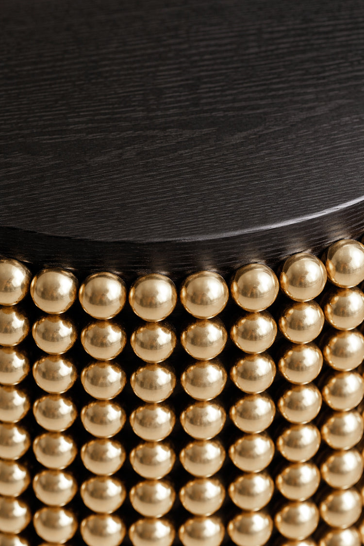 Sculptural side table featuring gold metal spheres and black ash tabletop, designed by Railis Kotlevs