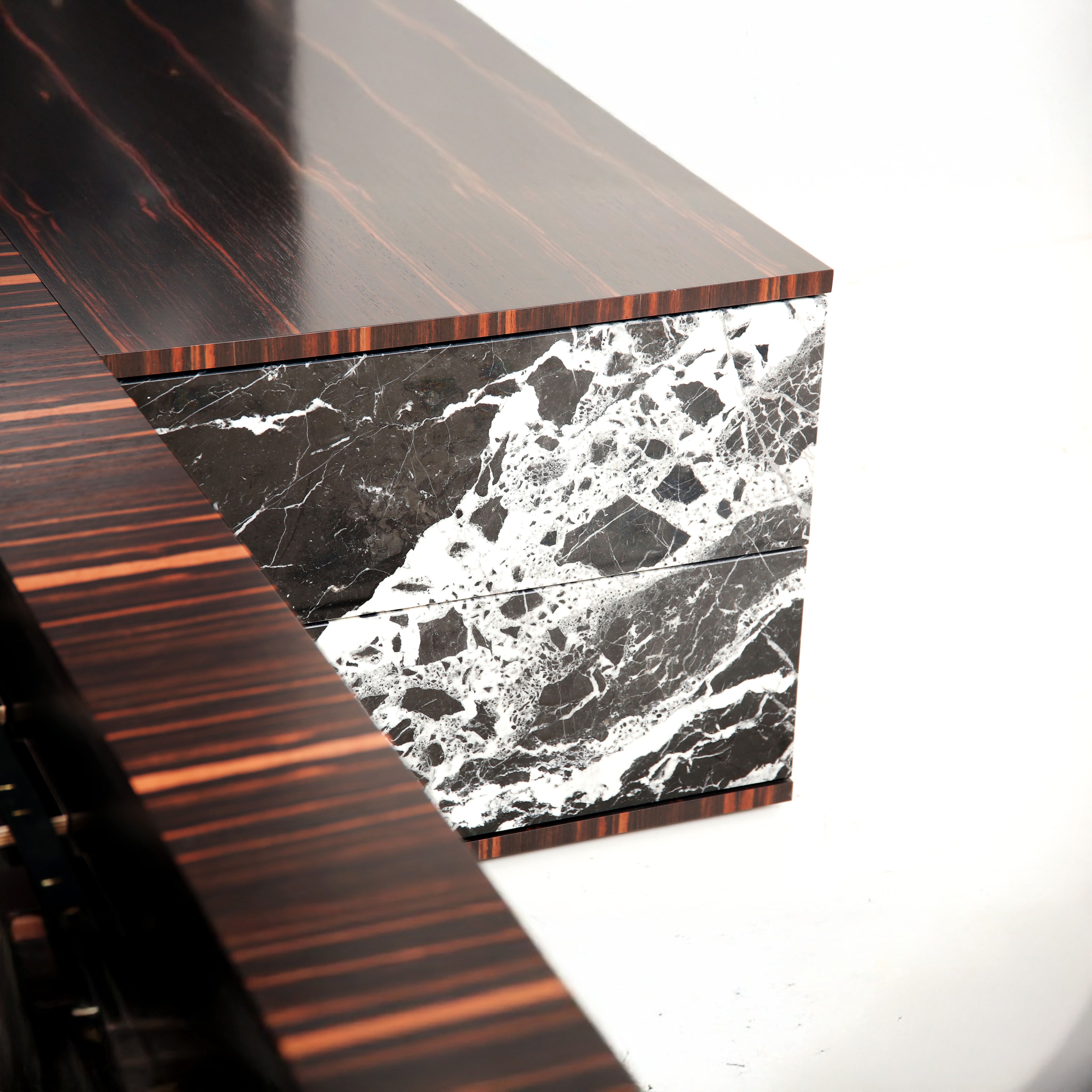 Detailed texture of polished marble and deep-toned ebony veneer on the Gullfoss Bed.