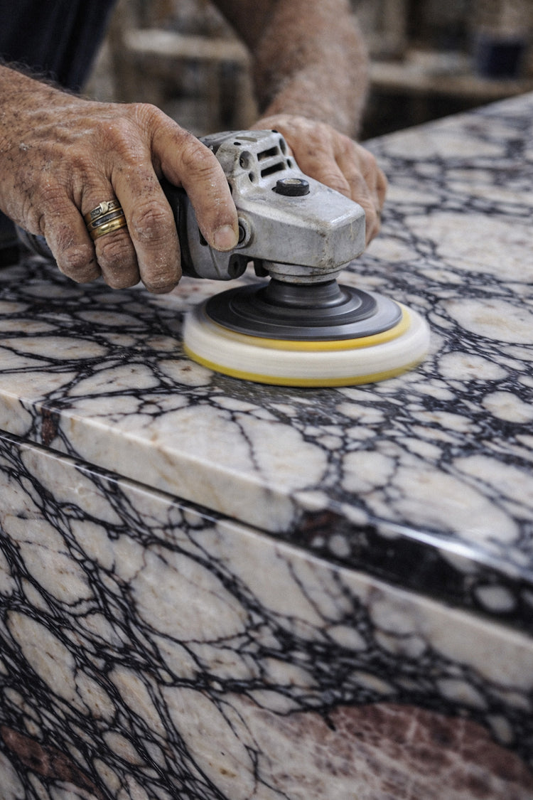 Person using a diamond sander on a marble surface