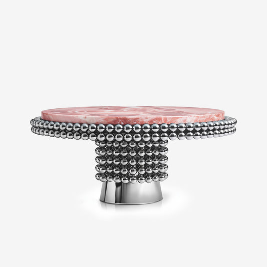 Lustra dining table with pink onyx top and polished chrome sphere base in modern interior.
