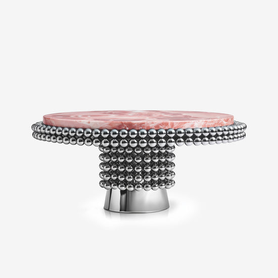 Lustra dining table with pink onyx top and polished chrome sphere base in modern interior.
