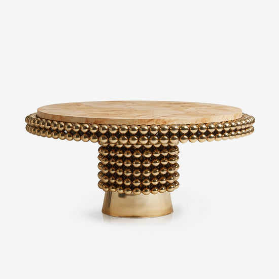 Round Lustra dining table in poplar burl veneer with polished brass sphere base.
