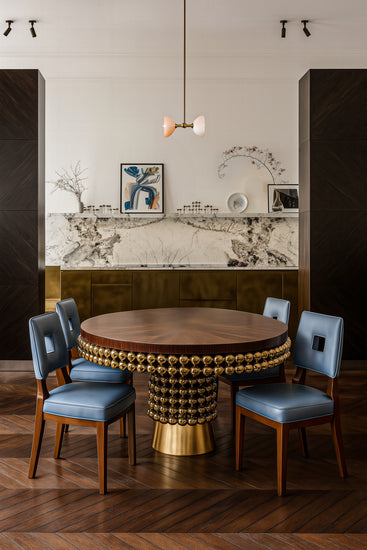 Statement dining table in polished brass and rich wood veneer for luxury interiors