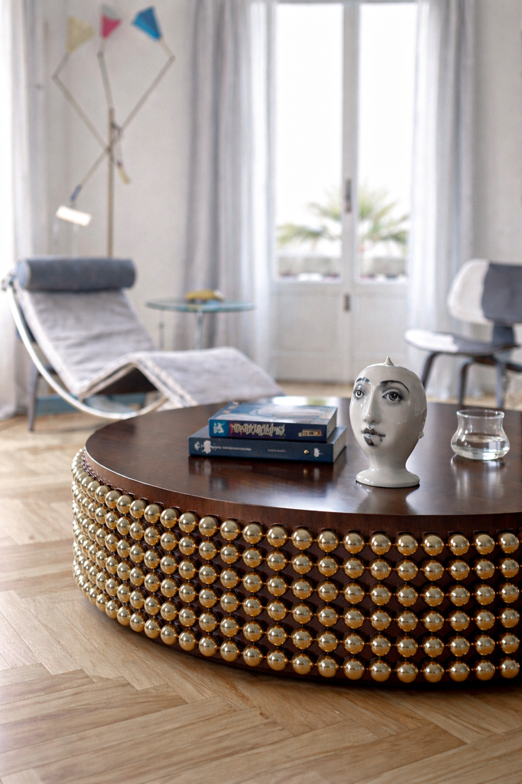 Sculptural Lustra coffee table with wenge top and gold spheres styled within a contemporary interior space, designed by Railis Kotlevs
