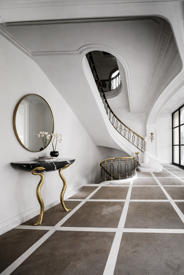 Elegant interior with a console table, mirror, and staircase in a stylish home.