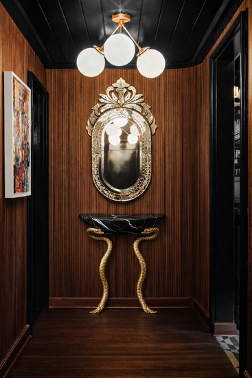Black Nero marble statement console with detailed brass serpent structure.