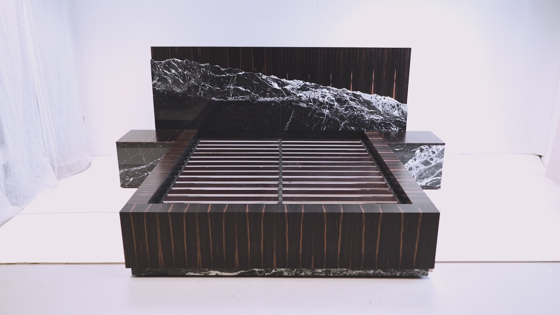 Detailed texture of polished marble and deep-toned ebony veneer on the Gullfoss Bed.